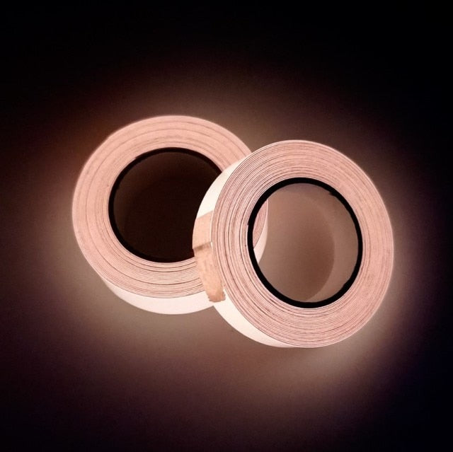 Two rolls of beige adhesive tape on a dark background with soft lighting