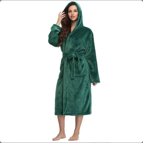 woman wearing a plush green hooded bathrobe with a waist tie standing barefoot on white background