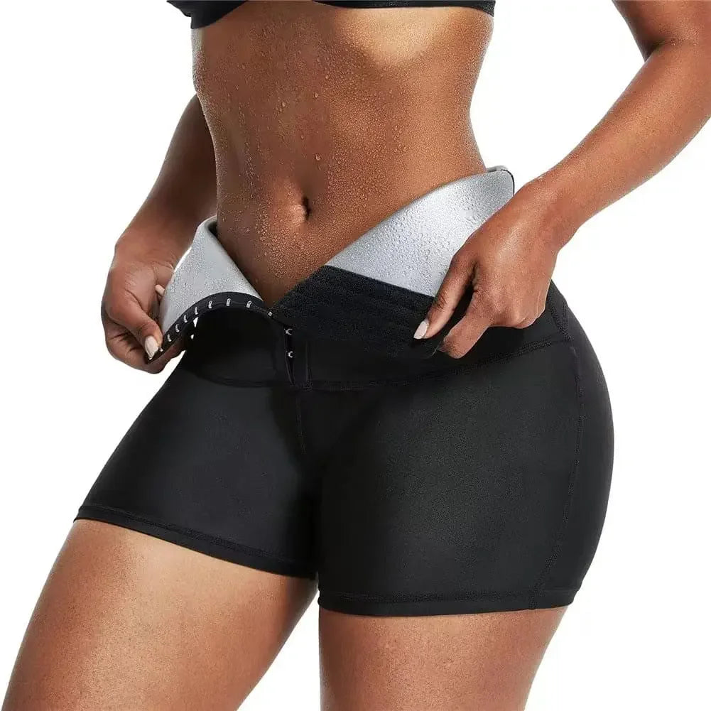 Close-up of a fit woman wearing black waist trainer shorts with hook closure, showing toned abs and sweat