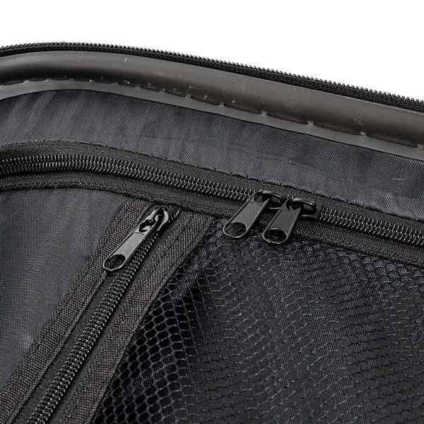 Close-up of black mesh and fabric compartments with multiple zippers on a storage bag