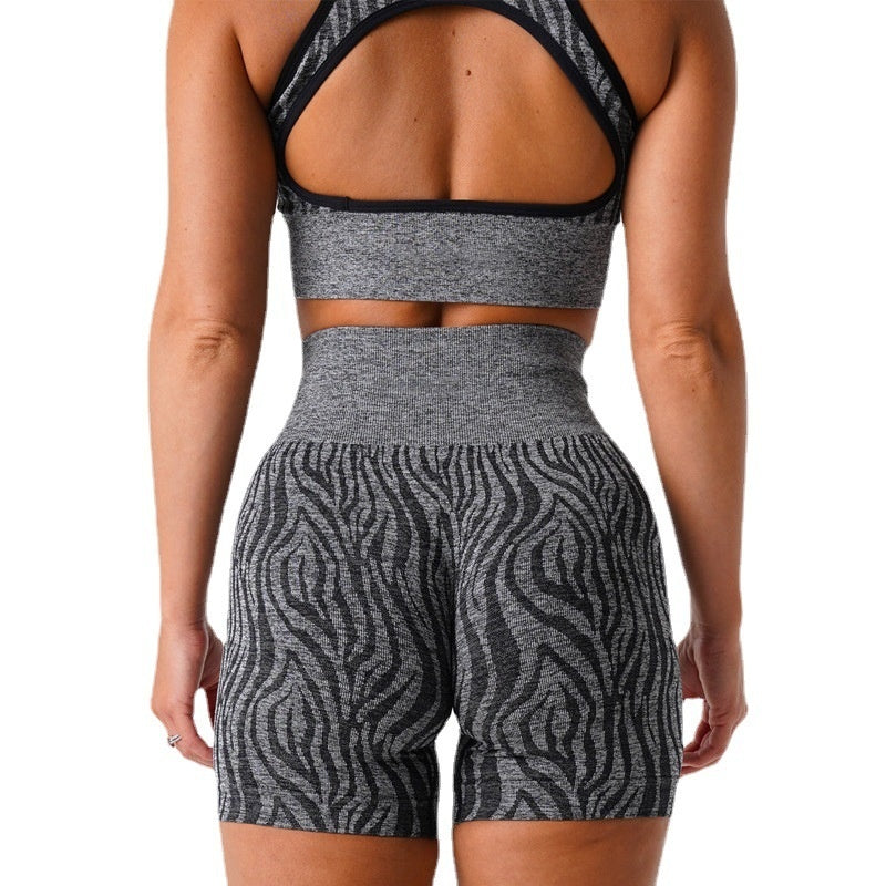 Woman wearing seamless gray and black zebra print workout shorts and matching sports bra from the back