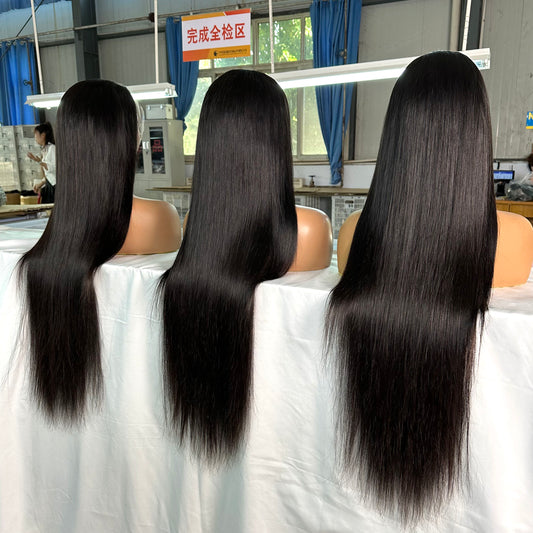 Three mannequin heads with long, straight black hair displayed in a bright workshop setting