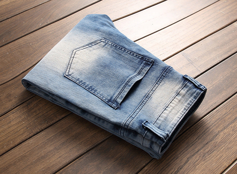 Folded light blue denim jeans with back pocket on wooden floor