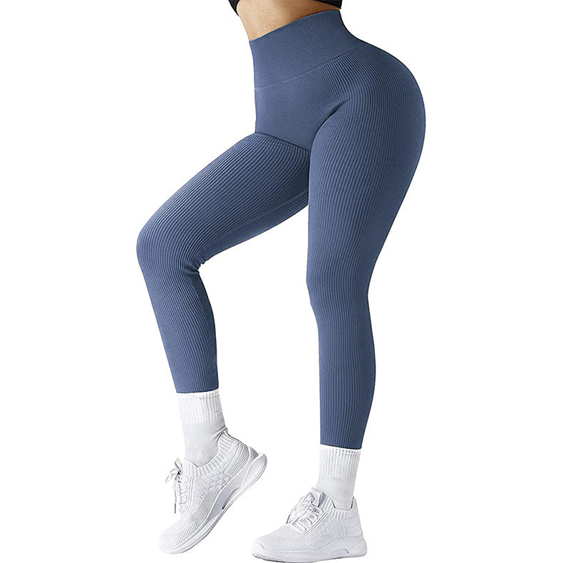 Woman wearing blue ribbed high-waisted leggings with white socks and white athletic sneakers
