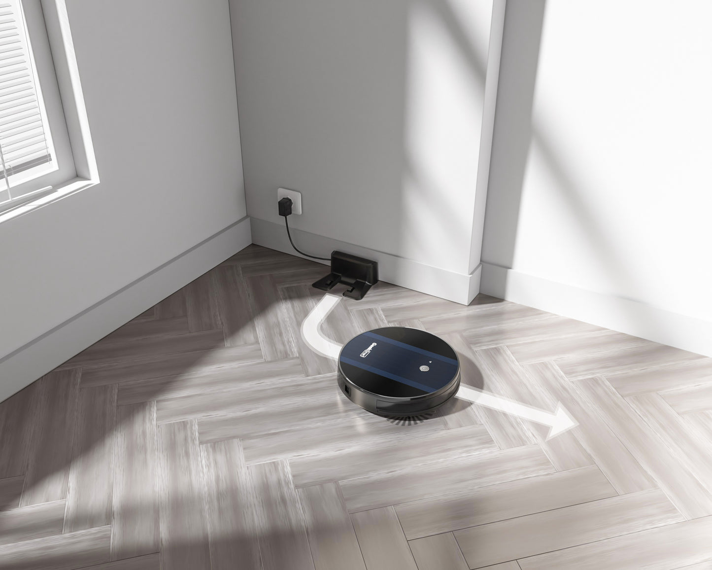 Black robotic vacuum cleaner moving away from charging dock on light wood herringbone floor in bright room
