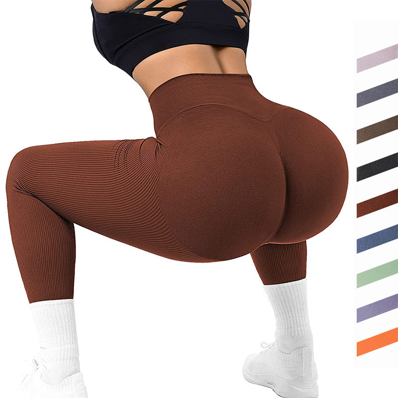 Woman in brown high-waist seamless leggings squatting, wearing black sports bra and white sneakers