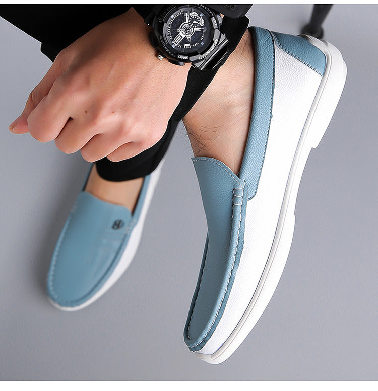 Close-up of stylish blue and white men's leather loafers worn with black pants and a black wristwatch