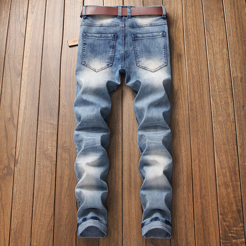Back view of faded blue denim jeans with brown belt laid on wooden floor