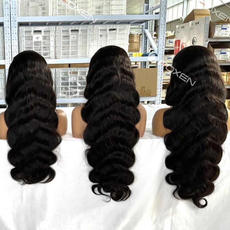 Three black wavy long hair wigs displayed on mannequin heads in a warehouse setting
