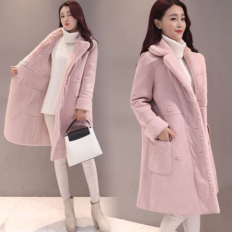 Woman modeling pink faux fur lined winter coat with white turtleneck, beige pants, boots, and black and white handbag