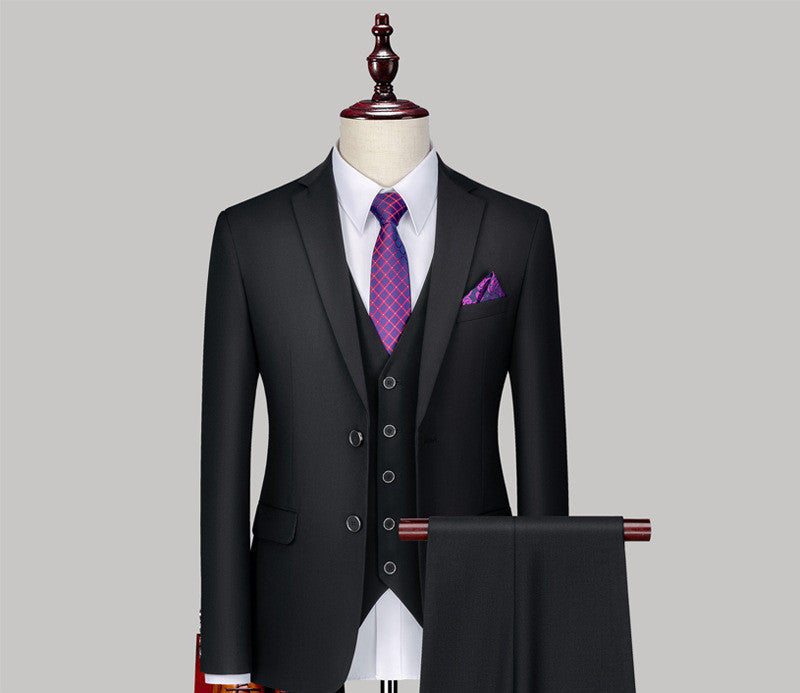 black three-piece suit on mannequin with white shirt, purple patterned tie, and matching pocket square