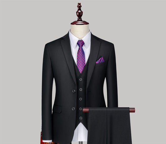 black three-piece suit on mannequin with white shirt, purple patterned tie, and matching pocket square