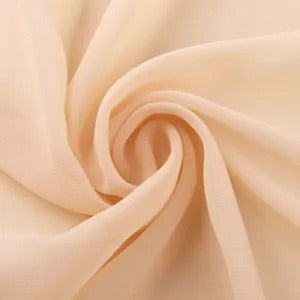 Close-up of beige soft fabric twisted in a swirl pattern, showcasing smooth texture
