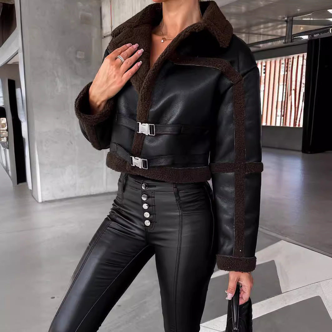 Woman wearing black faux leather cropped jacket with brown shearling trim and high-waisted black pants with buttons
