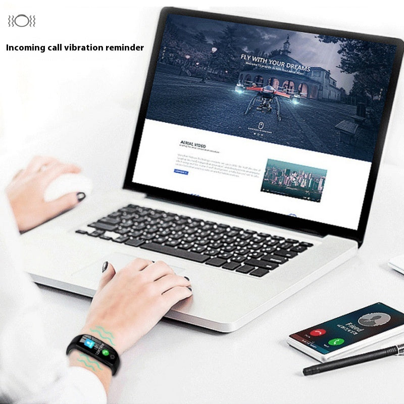 Person wearing a smart fitness band showing an incoming call vibration reminder while working on a laptop with drone technology website