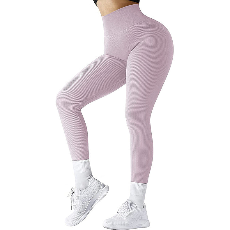 Woman wearing pink textured high-waisted leggings and white sneakers with white socks