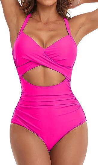 Woman wearing bright pink one-piece swimsuit with cutout waist and halter straps
