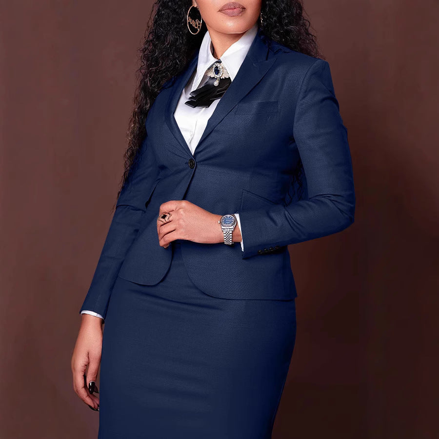 Woman wearing navy blue business suit and white shirt with decorative brooch on brown background