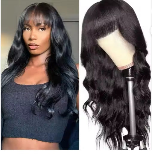 Woman with long black wavy hair and bangs wearing black top next to black wavy wig with bangs on mannequin