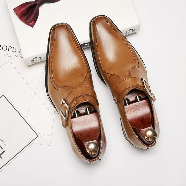Pair of polished tan leather monk strap dress shoes with wooden shoe trees on white background