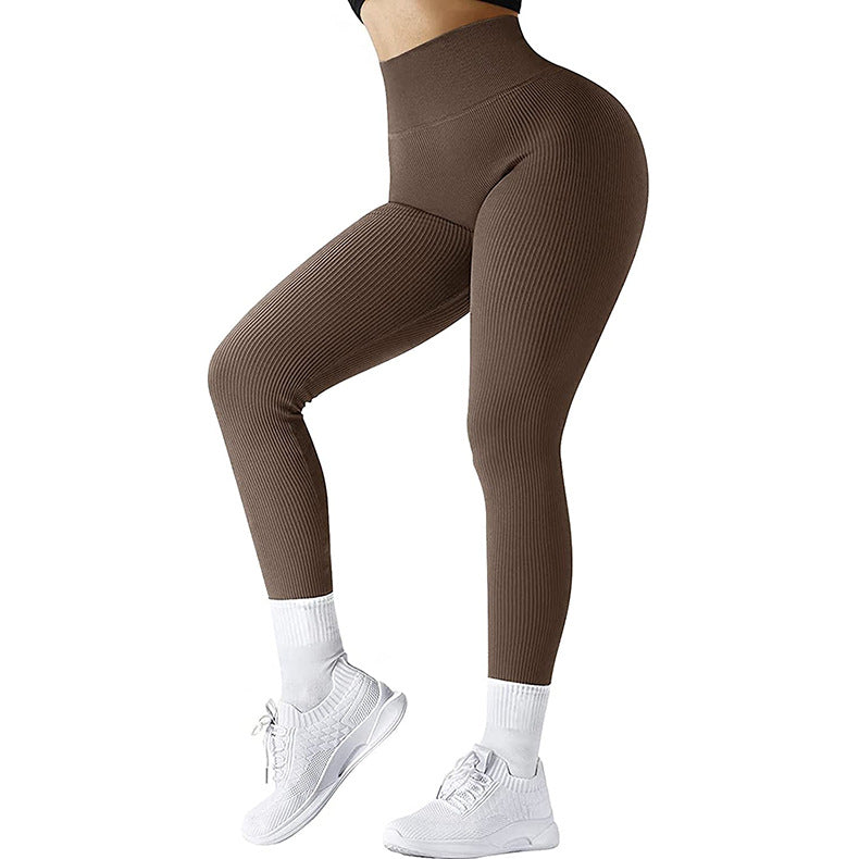 Woman wearing brown ribbed high-waisted leggings with white athletic socks and white sneakers