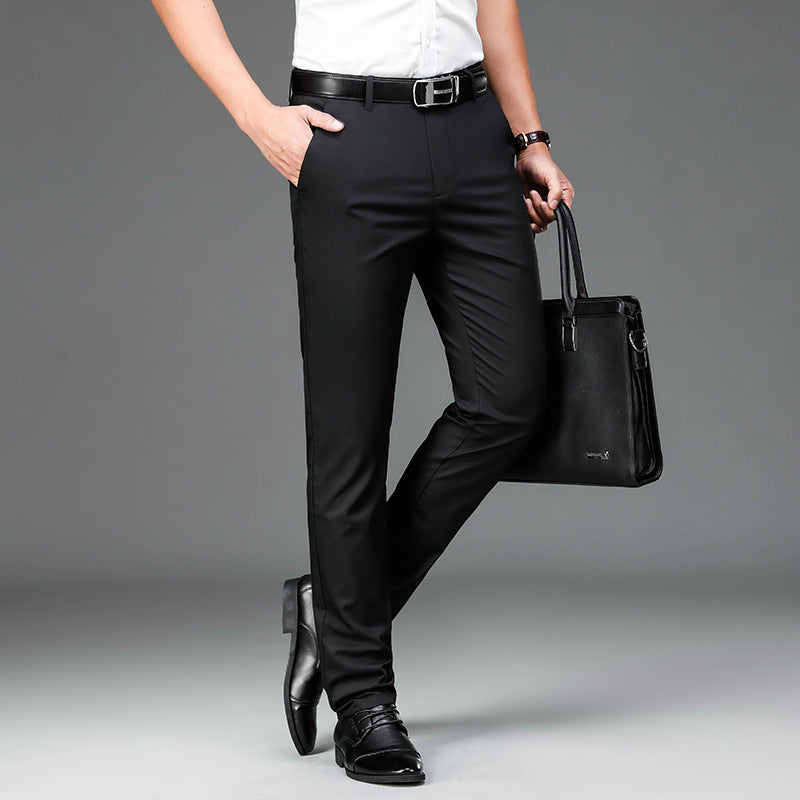 Man wearing slim fit black dress pants with black leather belt, black shoes, holding black leather briefcase