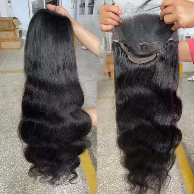 Long wavy black hair extensions and lace frontal piece held in hands on a showroom floor
