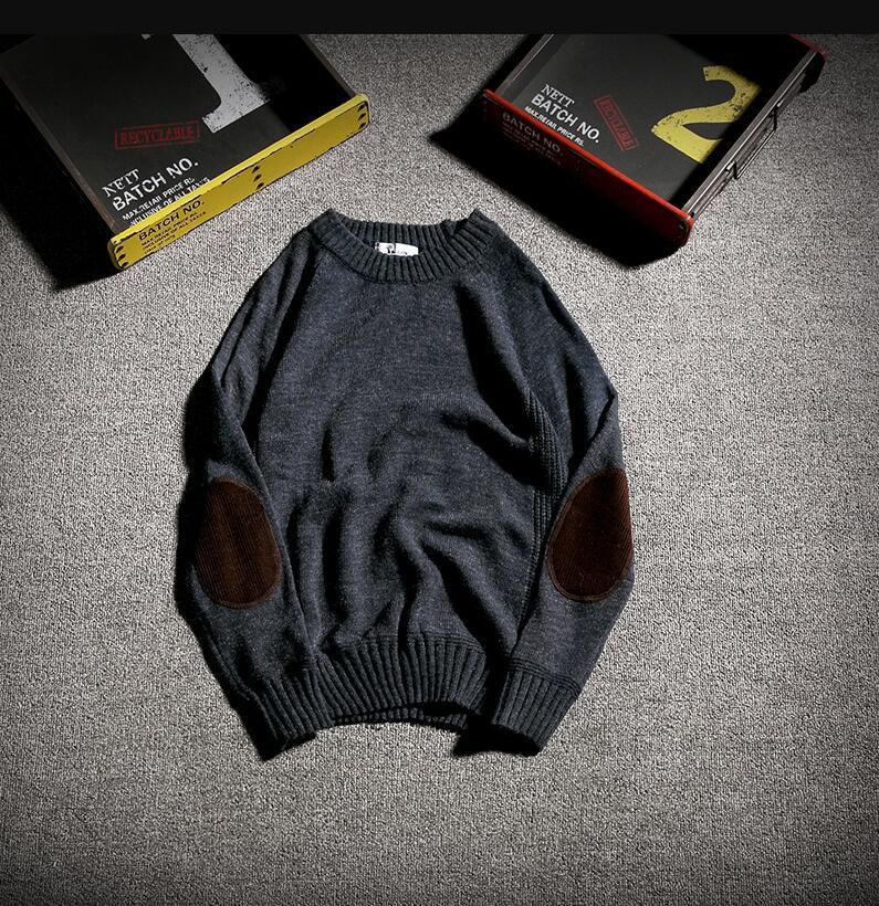 Dark gray knit sweater with brown elbow patches on gray carpet, vintage black boxes numbered 1 and 2