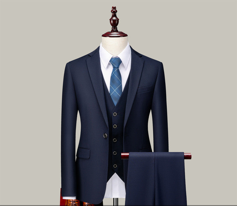 Navy blue three-piece suit with white dress shirt and blue plaid tie on mannequin