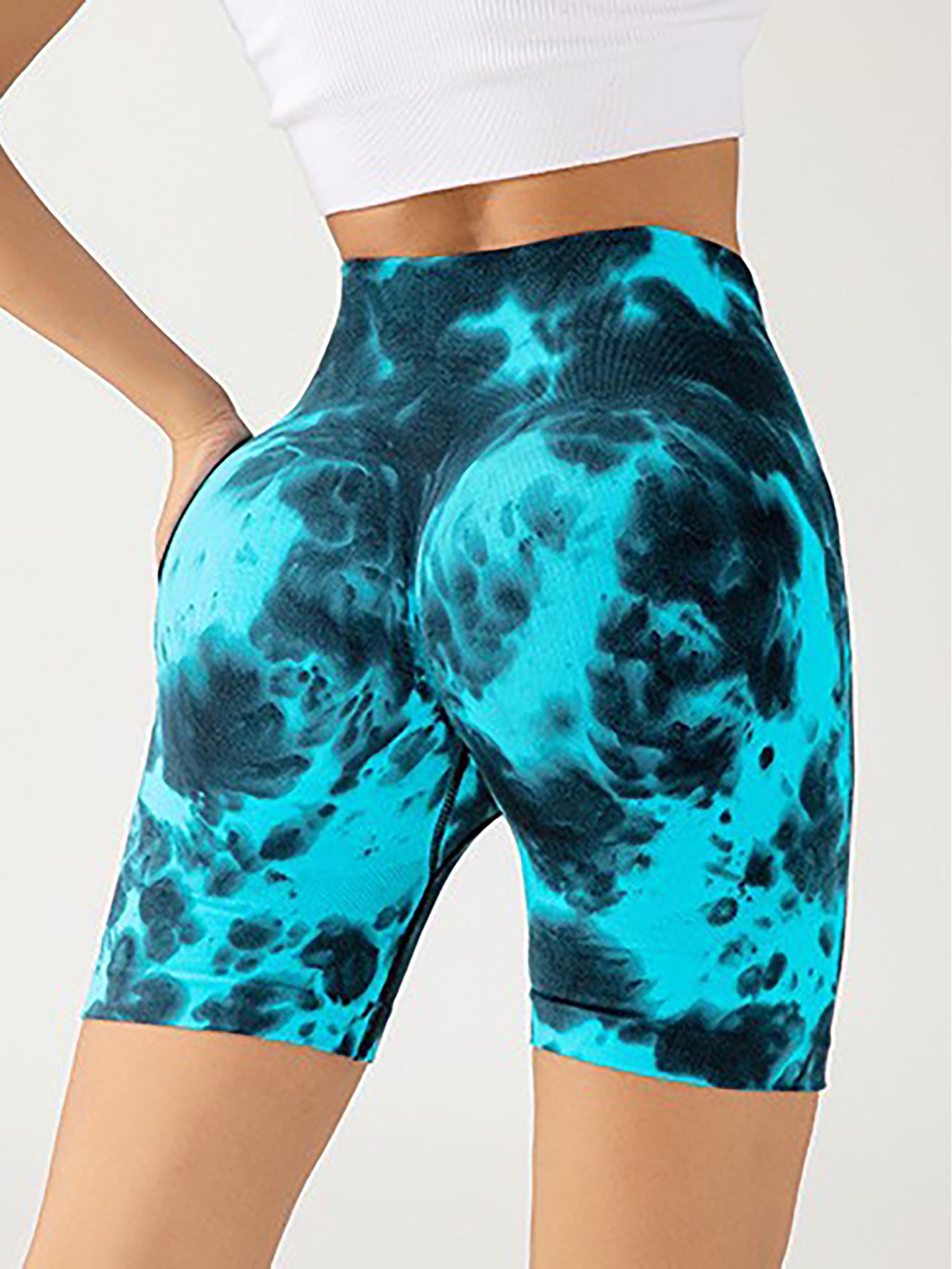 Close-up of woman wearing vibrant blue and black tie-dye high-waisted biker shorts