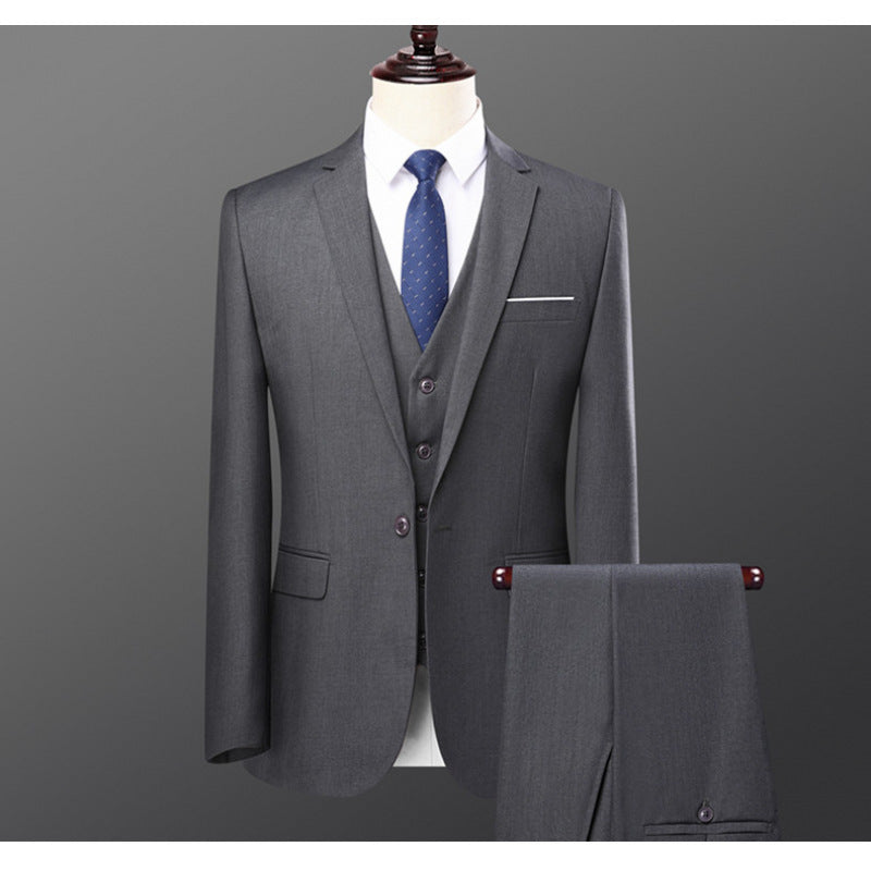 Men's gray three-piece suit with blue tie displayed on mannequin against gray background