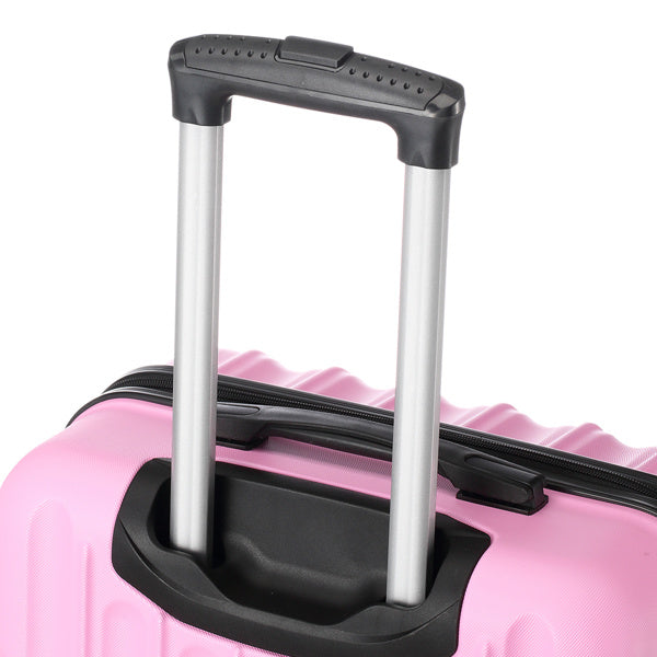 Close-up of pink hard shell suitcase with extended black and silver telescopic handle