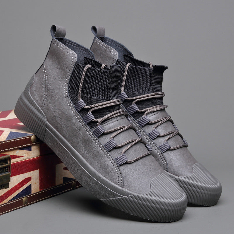 Stylish gray high-top sneakers with black elastic ankle collar and unique lacing, displayed on Union Jack box
