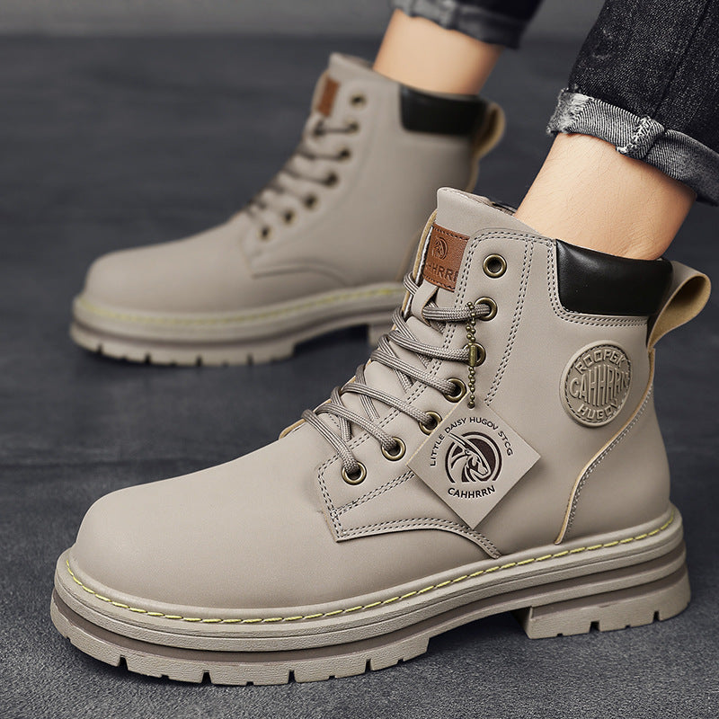 Beige men's casual lace-up boots with black padded collar and branded tag, worn with rolled jeans