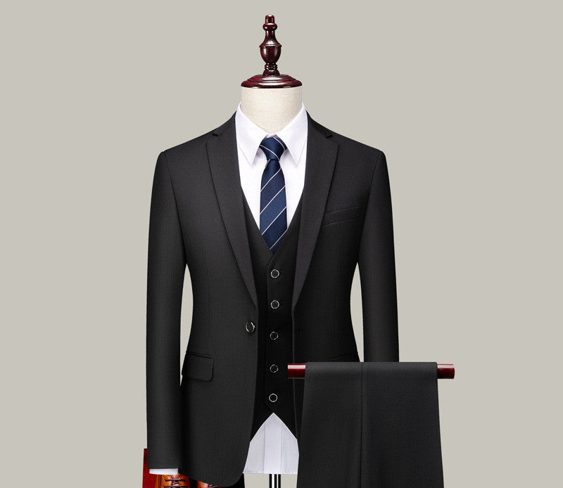 Black three-piece suit with white dress shirt and navy striped tie displayed on mannequin with matching trousers