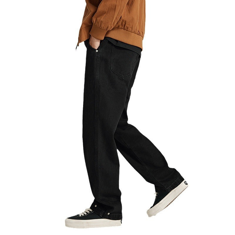 Person wearing black loose-fit jeans and black sneakers with white soles walking