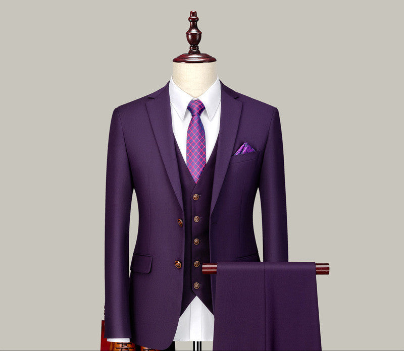 Tailored purple three-piece suit with white shirt, patterned tie, and pocket square on mannequin
