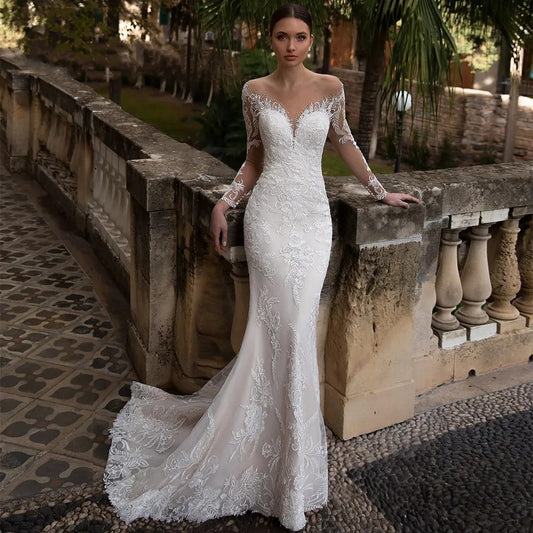 Bride in elegant white lace mermaid wedding dress with off-shoulder neckline in historic stone courtyard