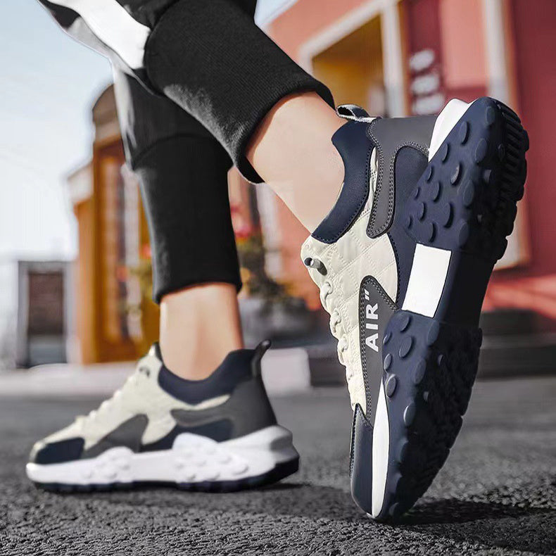 Close-up of person wearing black and white AIR branded sneakers on black asphalt outdoors