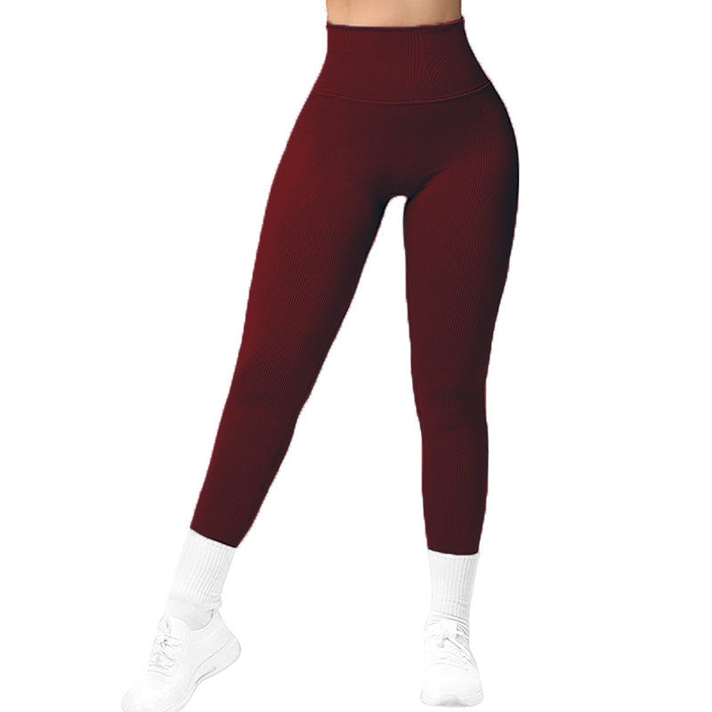 High-waisted burgundy ribbed leggings paired with white athletic socks and white sneakers