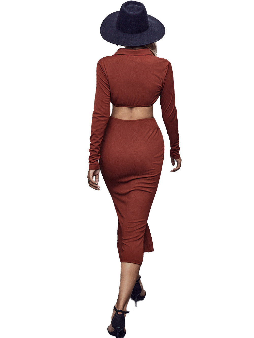 Woman in a rust-colored long-sleeve crop top and matching midi skirt with a black wide-brim hat and heels