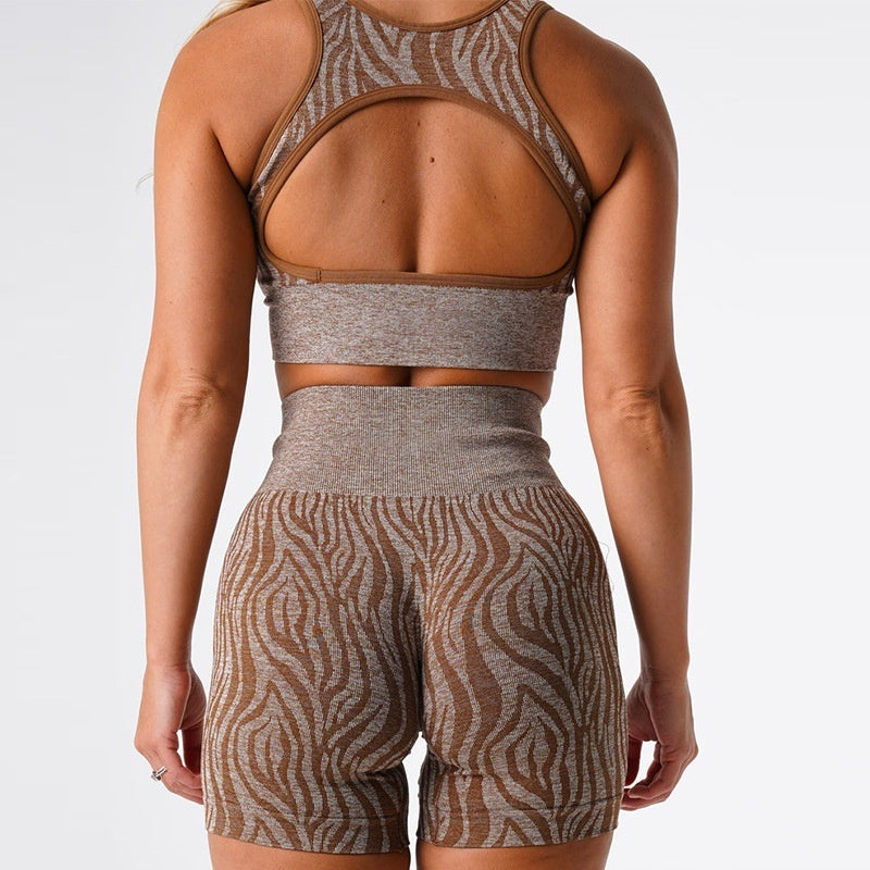 Woman wearing brown and beige zebra print seamless sports bra and high-waisted shorts activewear set from back