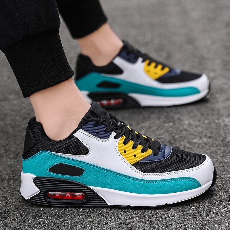 Close-up of stylish black, white, teal, and yellow athletic sneakers on asphalt surface