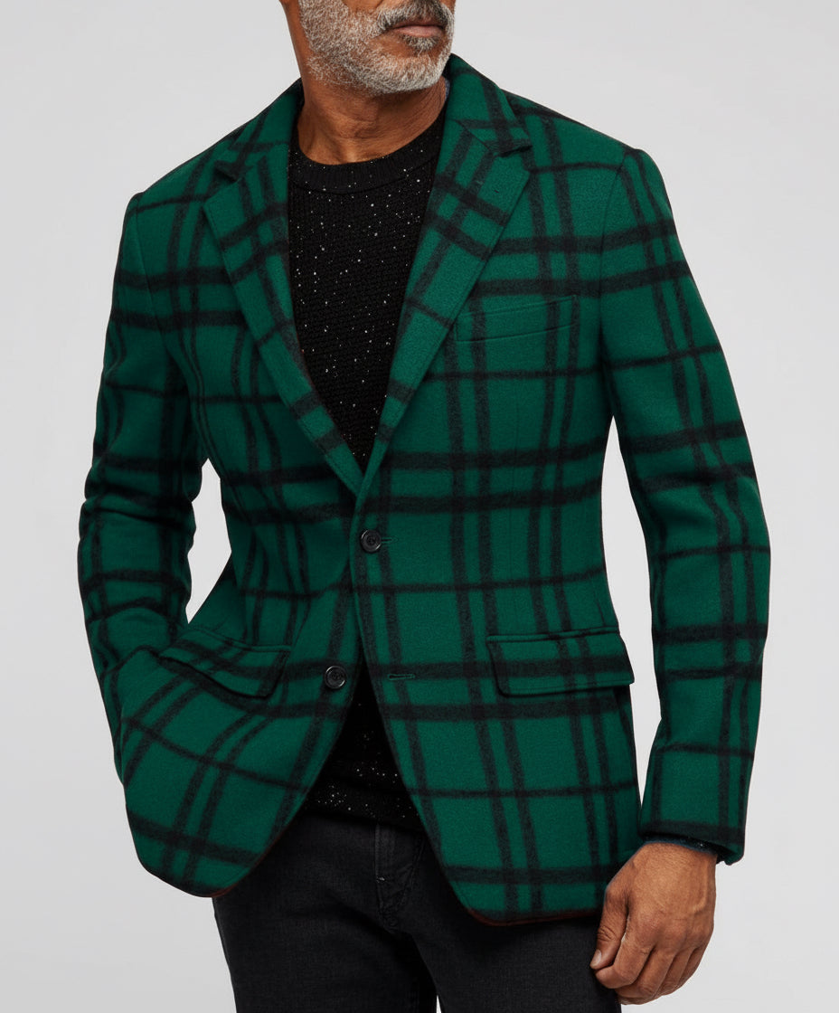 Man wearing green and black checkered blazer with black speckled sweater and black pants