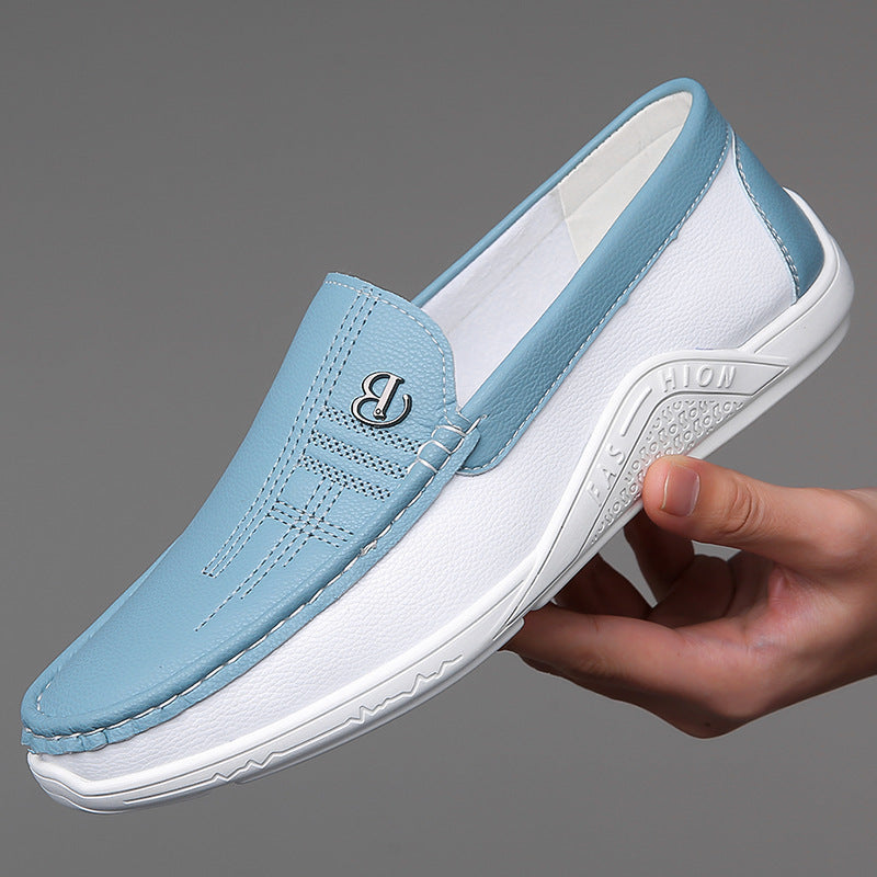 Hand holding a stylish blue and white leather slip-on casual shoe with rubber sole on gray background