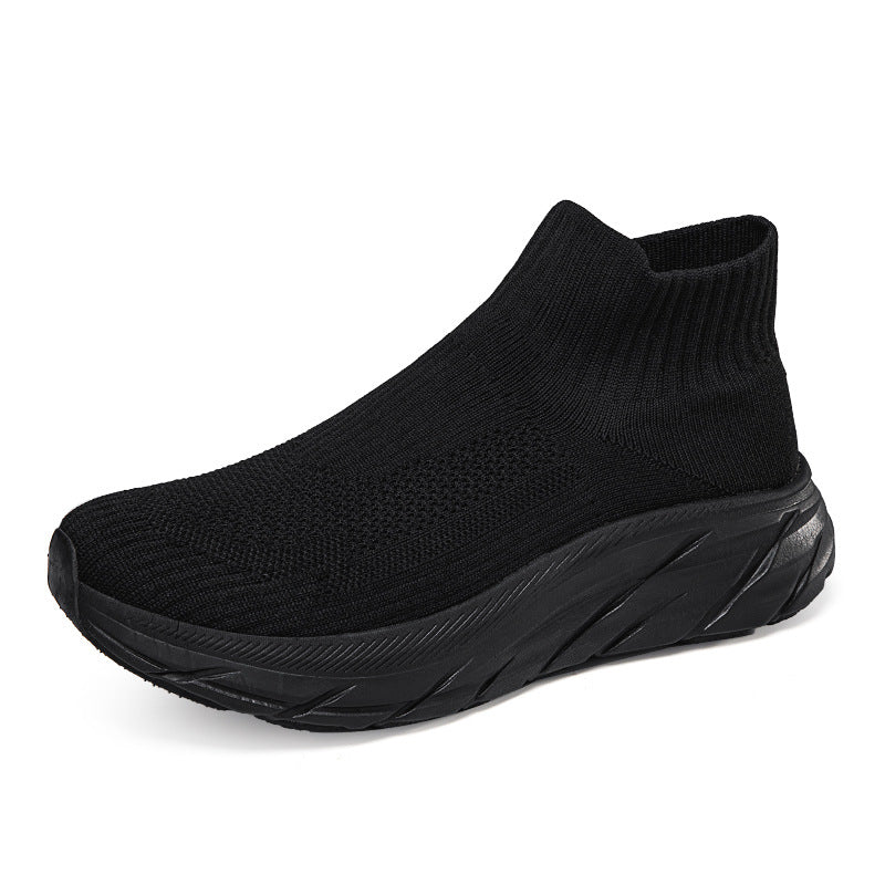 Black sock-style sneaker with knit upper and thick textured sole on white background
