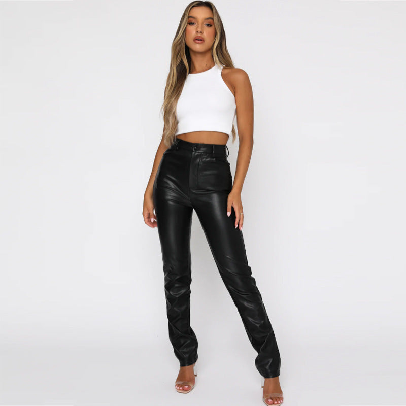 Model wearing white cropped tank top and high-waisted black faux leather pants on white background