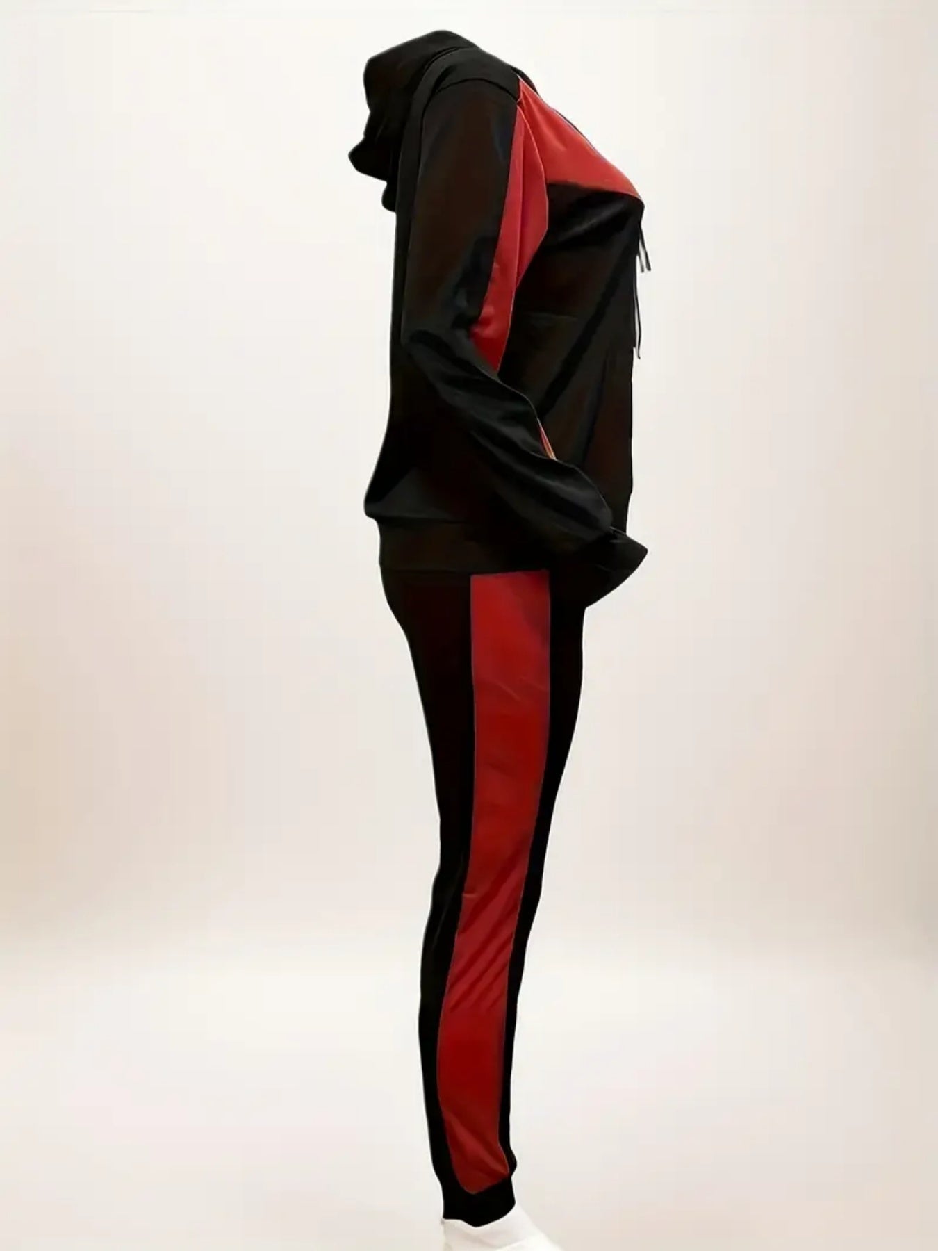 Side view of black and red hooded tracksuit with stripe design on pants and jacket