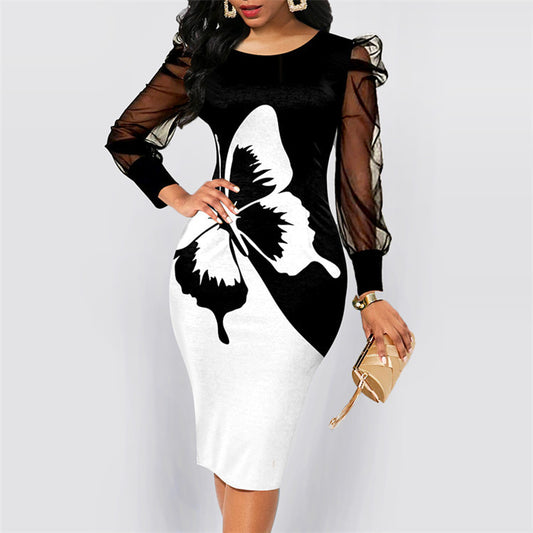 Woman in black and white butterfly print bodycon dress with sheer long sleeves holding beige clutch