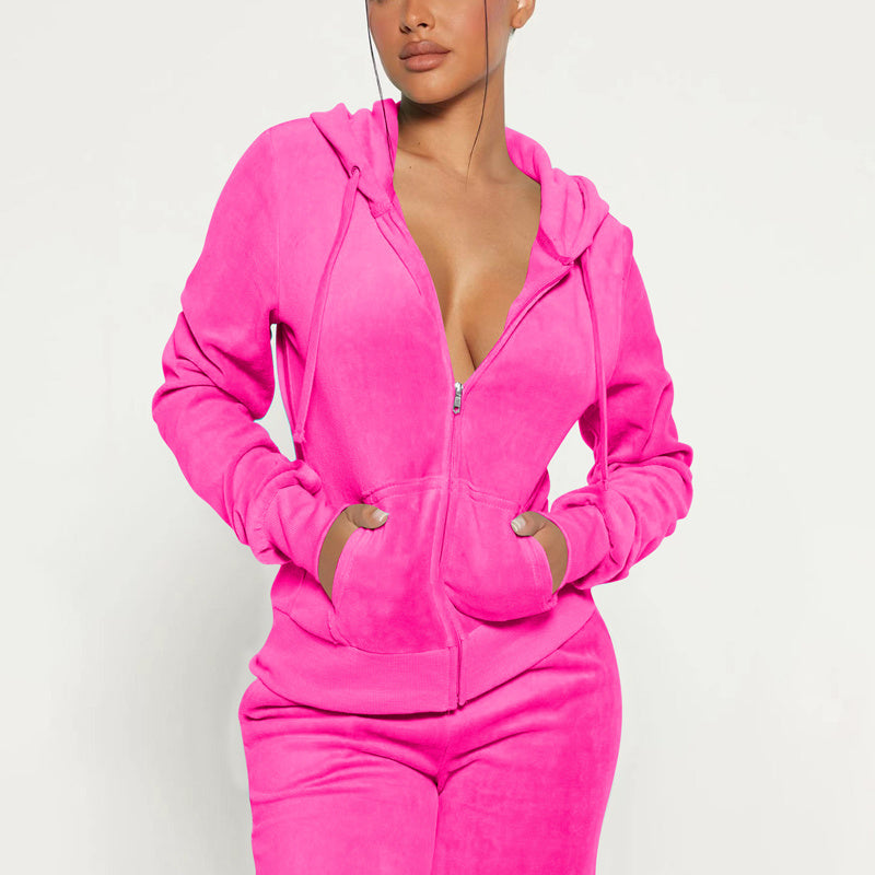 Woman wearing bright pink zip-up hoodie and matching pants, hands in pockets, casual lounge wear